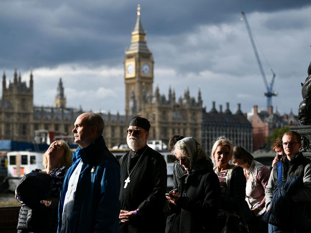 Members of the public stand in the queue as they wait in line to pay their respects to the late Queen Elizabeth II in London on Thursday.