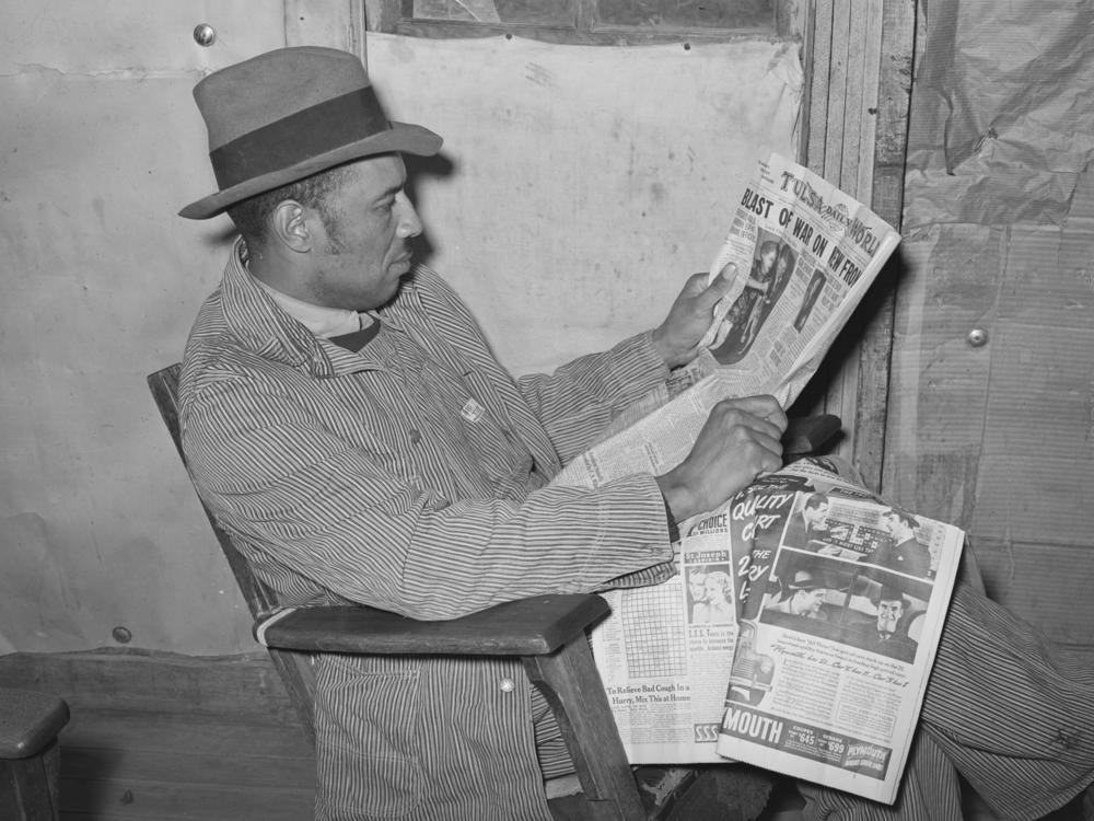 Ken Burns' new three-part documentary, <em>The U.S. and the Holocaust,</em> explores what everyday Americans knew — or didn't know — about what the Nazis were doing in Europe. Above, a tenant farmer reads a newspaper in Creek County, Okla., in February 1940.