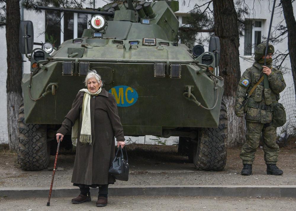 Margarita Khanaghyan, 81, walks past Russian peacekeeping forces in the town of Lachin on Nov. 26, 2020.