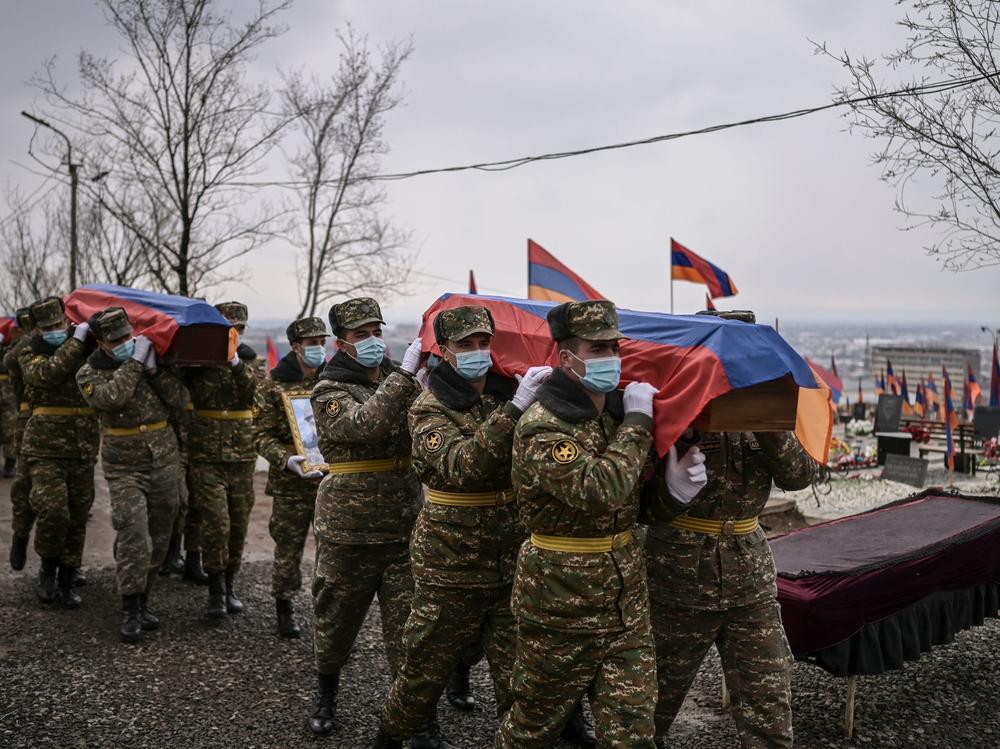 Soldiers carry coffins during funerals at a military cemetery in Yerevan, Armenia's capital, on March 2, 2021, for fighters killed during the war in Nagorno-Karabakh.
