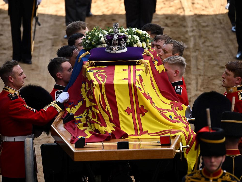 Pallbearers from the Queen's Company, 1st Battalion Grenadier Guards, prepare to carry the coffin of Queen Elizabeth II into Westminster Hall at the Palace of Westminster in London on Wednesday to lie in state following a procession from Buckingham Palace. Elizabeth's funeral is Monday.