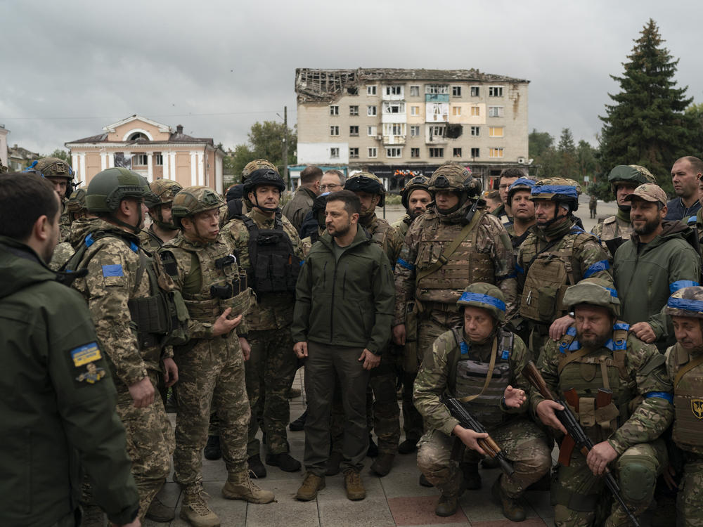 Ukrainian President Volodymyr Zelenskyy stands with soldiers after attending a national flag-raising ceremony in Izium, Ukraine, on Wednesday. Zelenskyy thanked soldiers for their efforts in retaking the area, as the Ukrainian flag was raised in front of the burned-out city hall building.