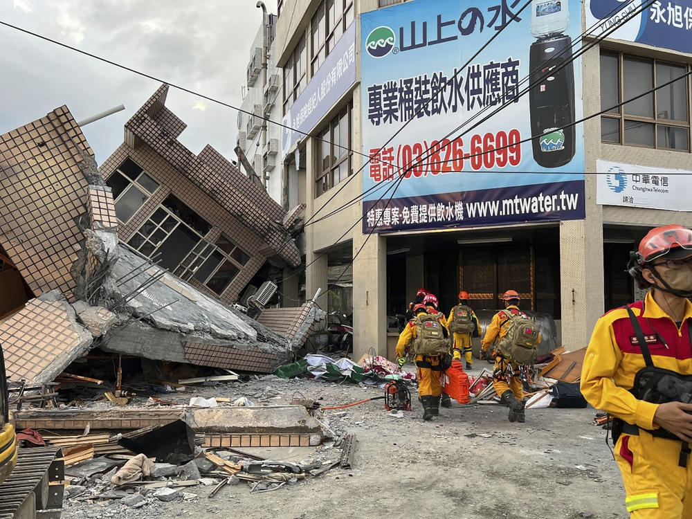 This photo provided by Hualien County fire department show firefighters in the search for trapped victims in a collapsed residential building following earthquake in Yuli township in Hualien County, eastern Taiwan, Sunday, Sept. 18, 2022.