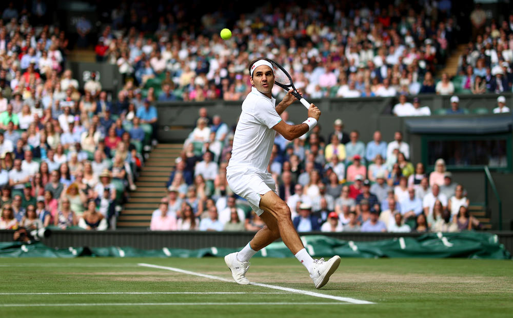 Federer plays a backhand during in singles match during Wimbledon 2021.
