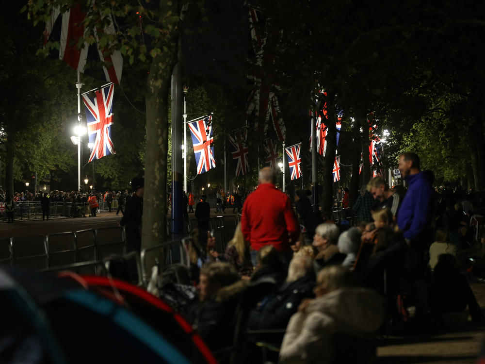 Groups of people camp outside Buckingham Palace in London.