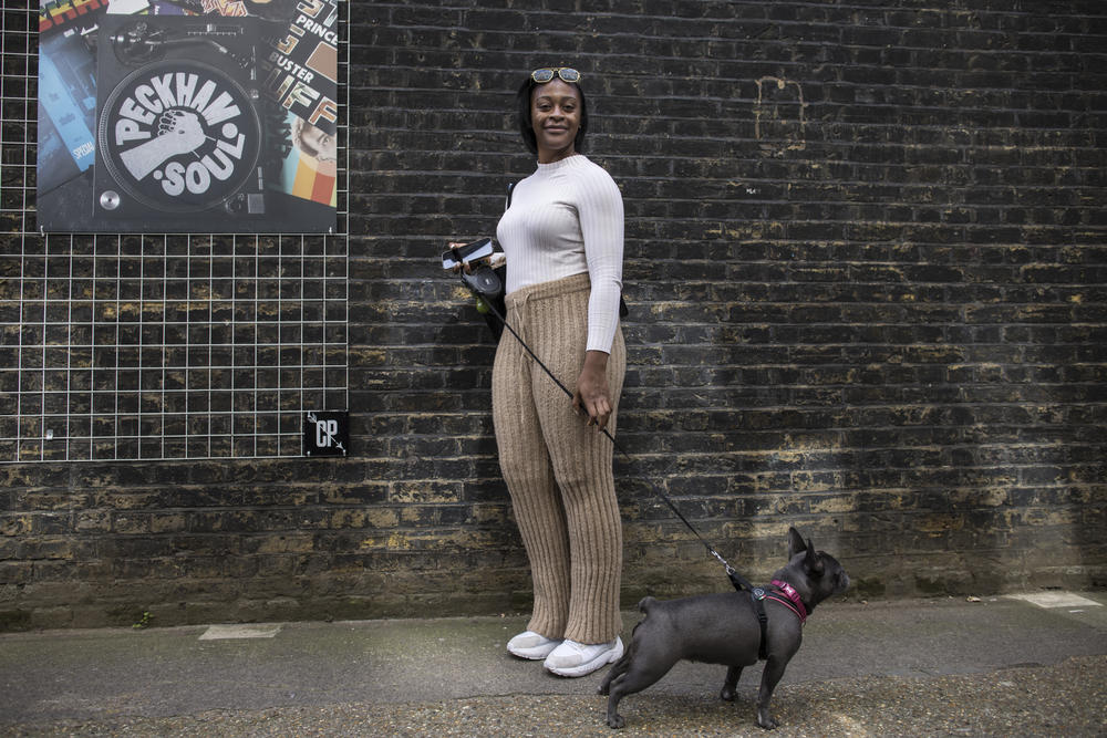 Hortence Mbyi poses with her dog after speaking about her views on the recent events surrounding the queen's death and the monarchy at the Peckham Festival in London.