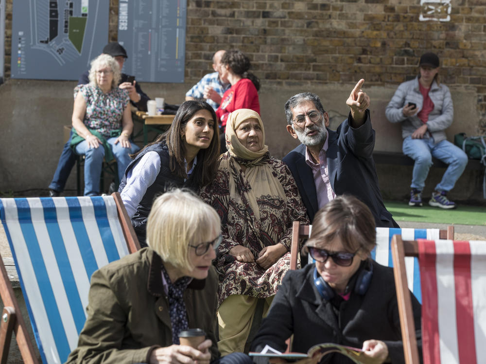 Sajida Khan, center wearing a headscarf, enjoys the musical entertainment at Peckham festival, where she spoke about her views on the recent events surrounding the queen's death and the monarchy.