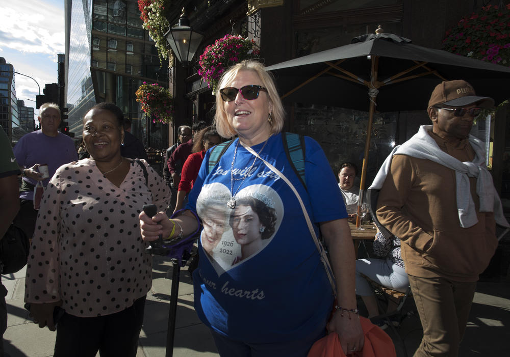 Maria Donderichi wears a commemorative shirt in remembrance of Queen Elizabeth II near Buckingham Palace.