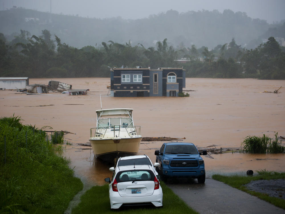 A home is submerged in floodwaters caused by Hurricane Fiona in Cayey, Puerto Rico, on Sunday. Authorities said three people were inside the home and were reported to have been rescued.