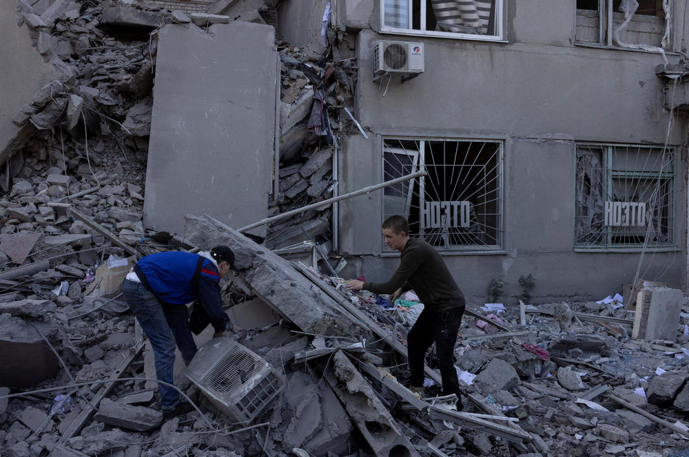 People clean the debris of a residential building destroyed by a strike, amid Russia's invasion of Ukraine, in Mykolaiv on Sept. 14.