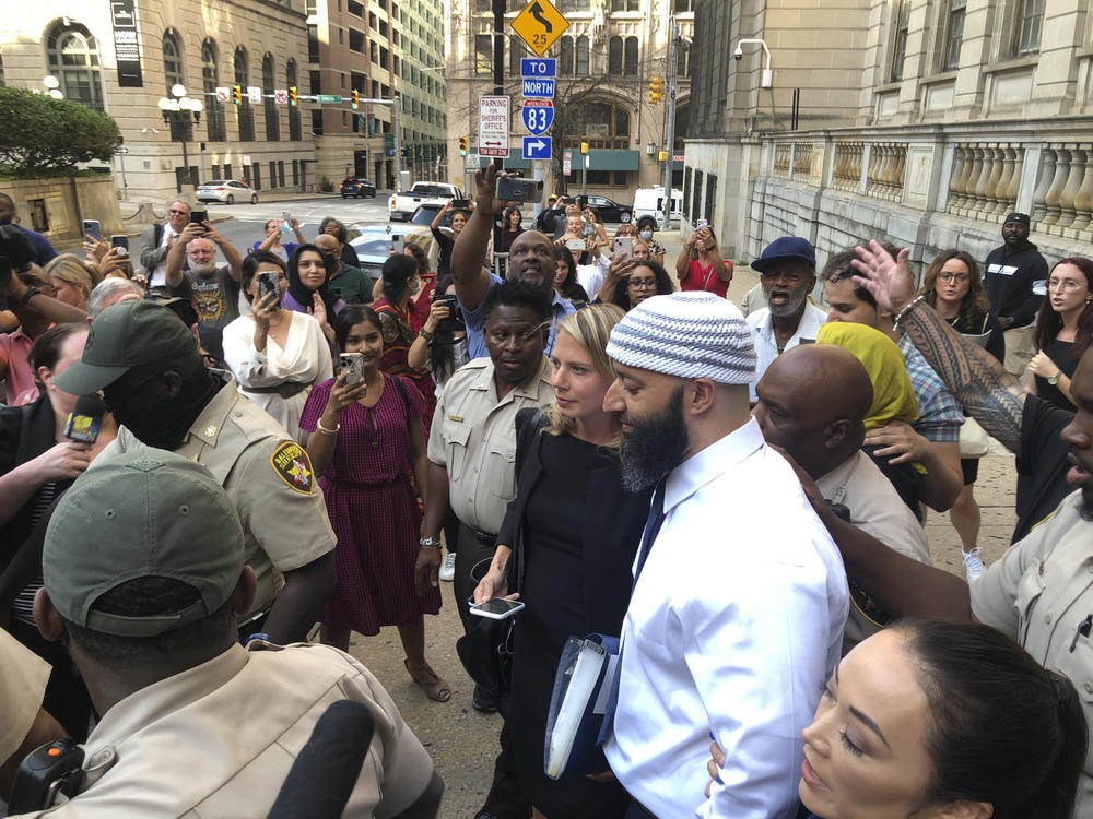 Adnan Syed, center, leaves the Cummings Courthouse in Baltimore on Monday. A judge has ordered the release of Syed after overturning his conviction for a 1999 murder that was chronicled in the hit podcast <em>Serial</em>.