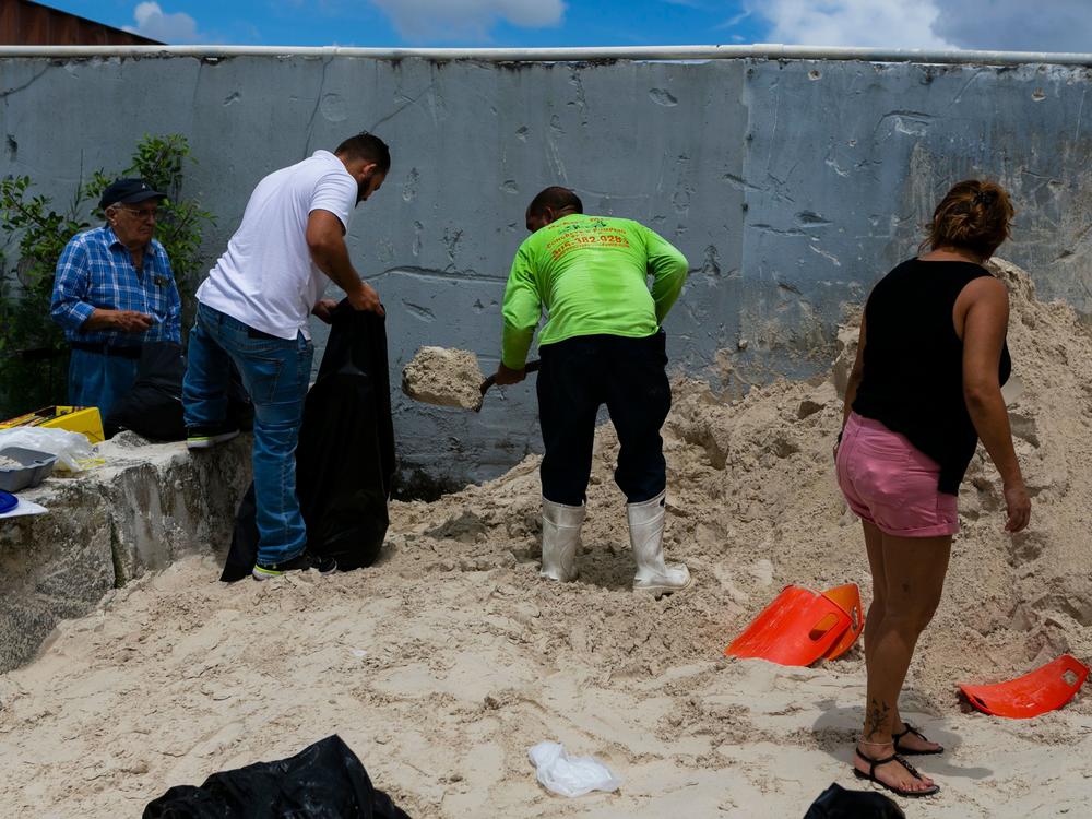 People fill sandbags in West Miami in 2019 in preparation for Hurricane Dorian. South Florida is home to millions of Latino people, and is at increasing risk for floods from sea level rise and more powerful hurricanes due to climate change.