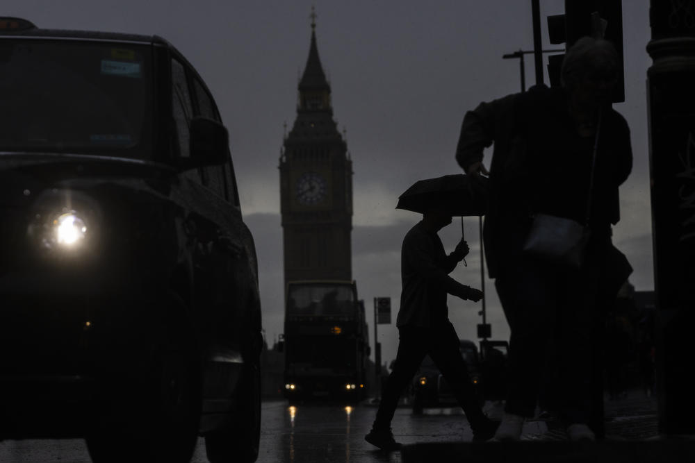 People walk across Westminster Bridge Road opposite the Houses of Parliament as British Prime Minister Liz Truss announces her plans on capping energy bills earlier this month.