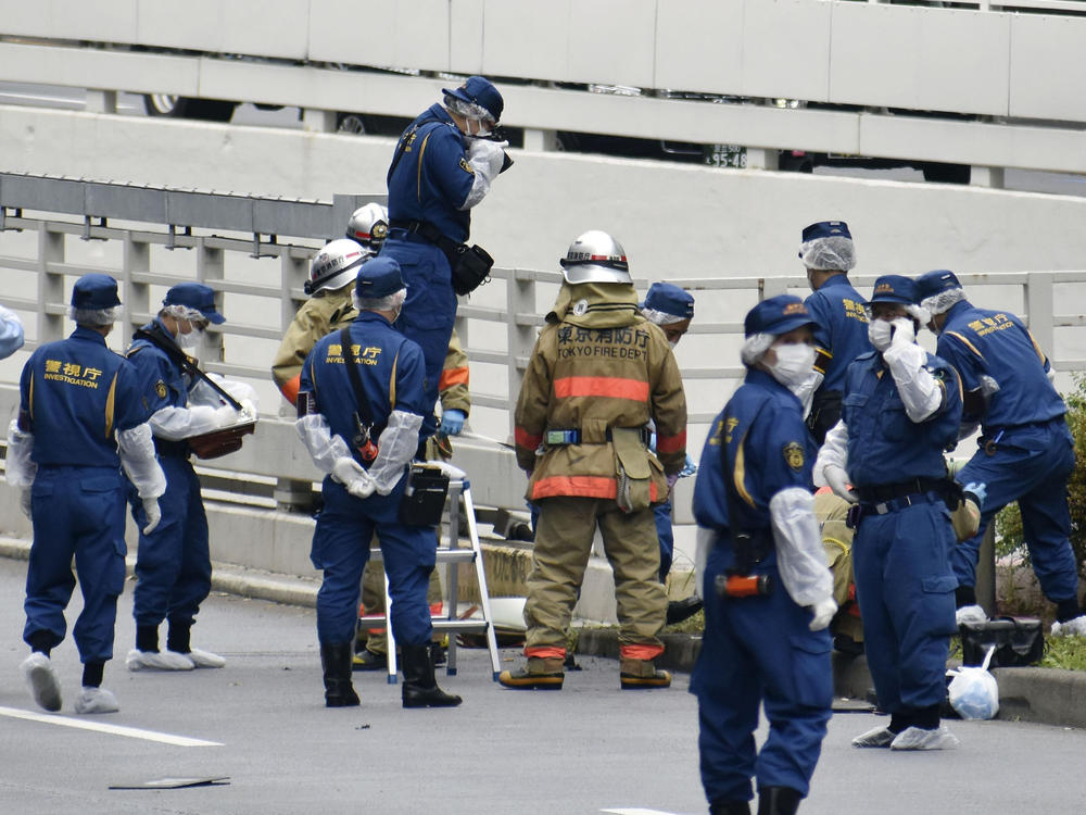 Police and firefighters inspect the scene where a man is reported to set himself on fire, near the Prime Minister's Office in Tokyo on Wednesday.