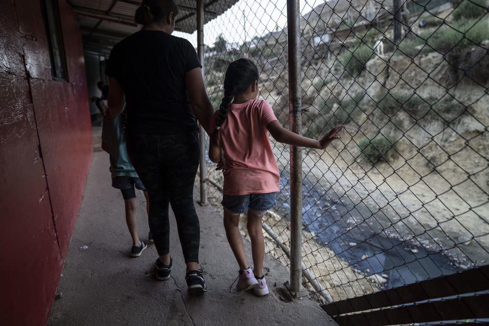 The mother and daughters of the Gutierrez family go for a walk around the shelter.