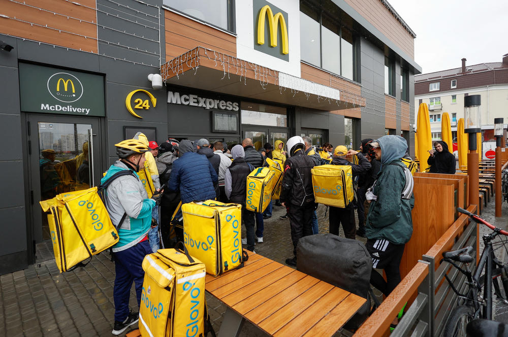 Glovo food delivery couriers wait to pick up orders outside a McDonald's restaurant after the chain reopened in Kyiv on Tuesday.
