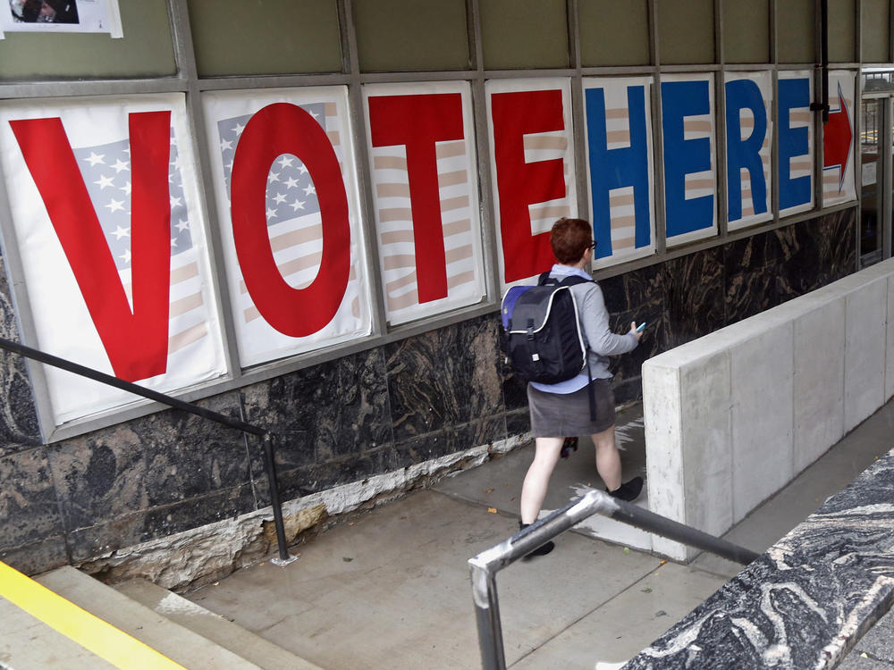 A voter passes large signs spelling out 