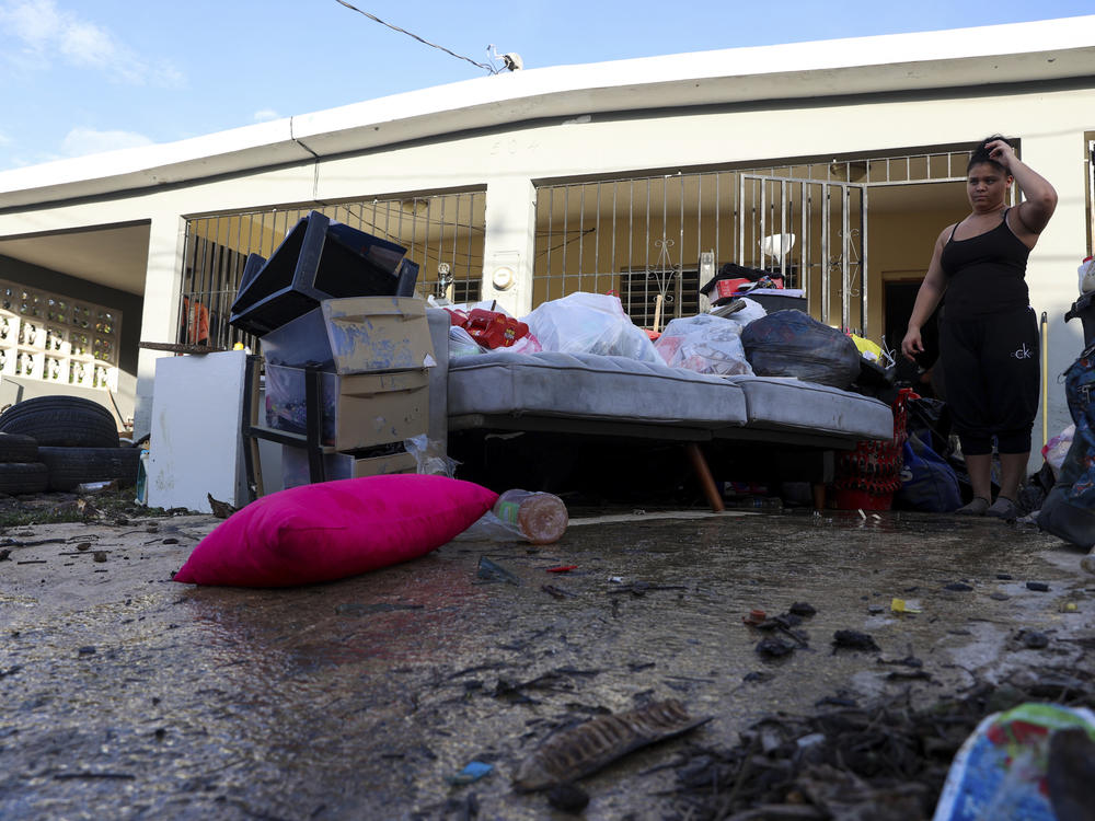 A woman looks at her water-damaged belongings after flooding caused by Hurricane Fiona tore through her home in Toa Baja, Puerto Rico, on Tuesday.