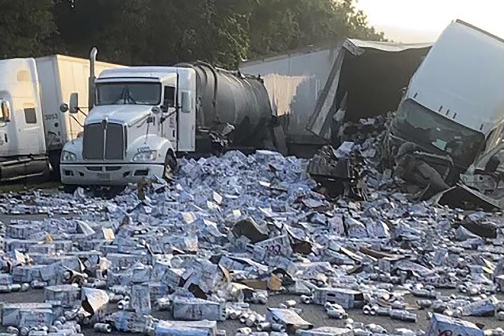 In this photo provided by Florida Highway Patrol, cases of Coors Light beer are strewn across a highway after two semitrailers collided on a Florida highway on Wednesday near Brooksville, Fla.