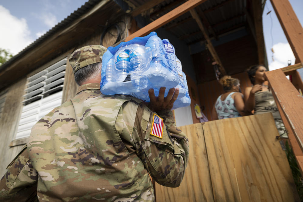 A member of the National Guard delivers water to residents in Ponce, Puerto Rico, on Wednesday.