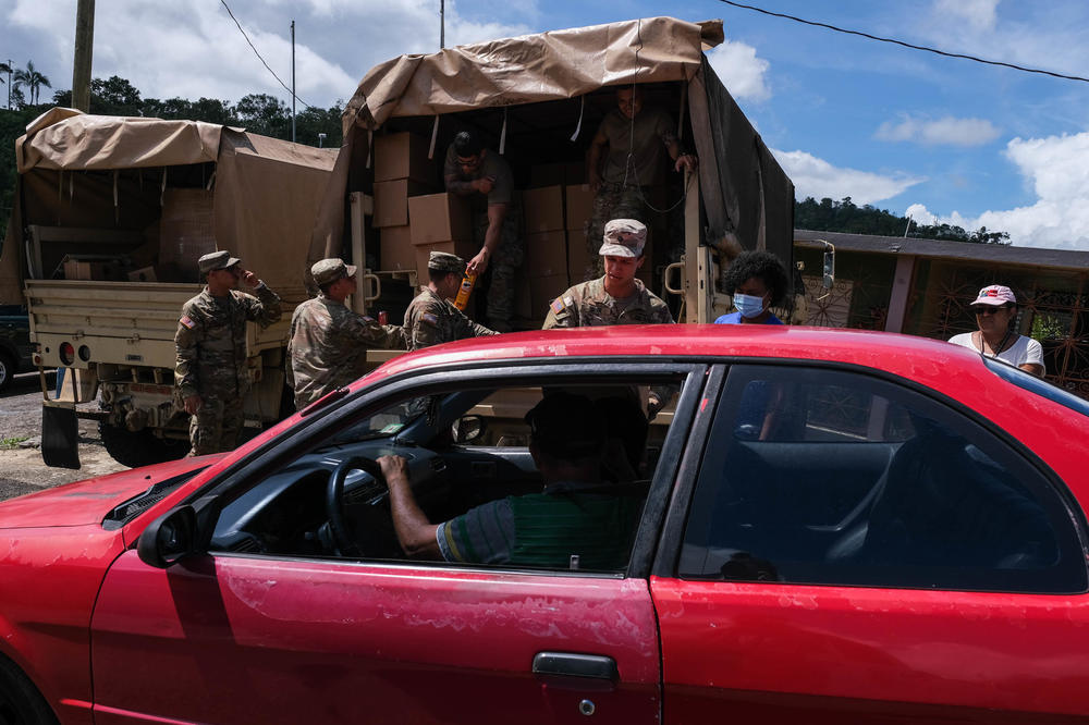 The Department of Family of Puerto Rico and the National Guard distribute food at an intersection of the community of Orocovis.