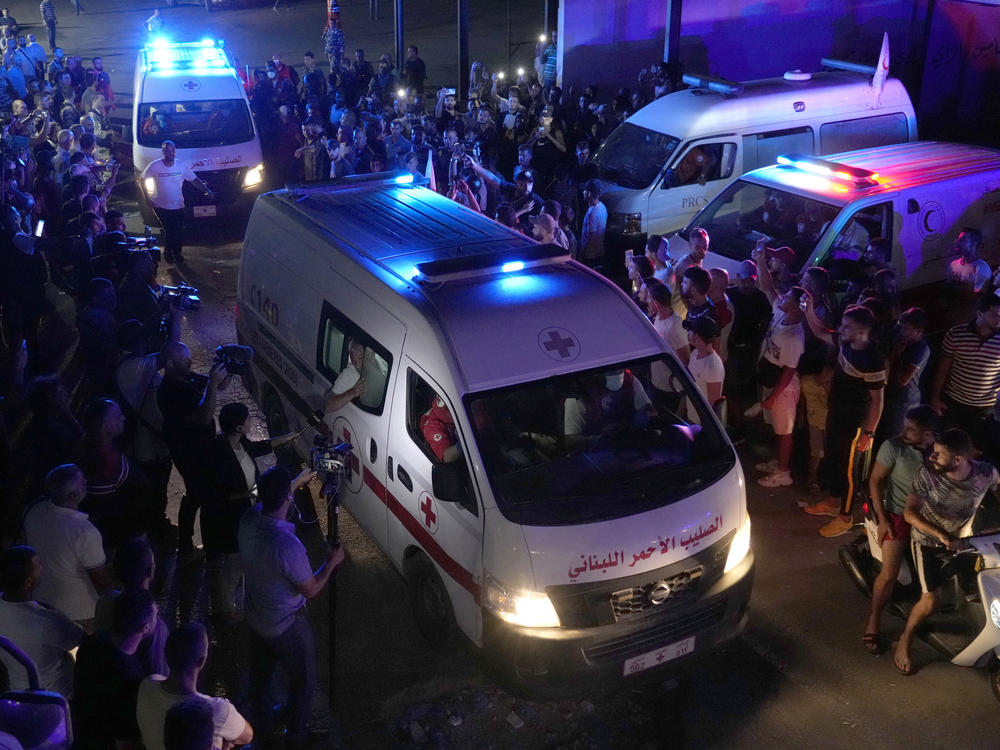 Lebanese Red Cross ambulances, carrying the bodies of people who died in a boat sinking, cross between Lebanon and Syria on Friday.