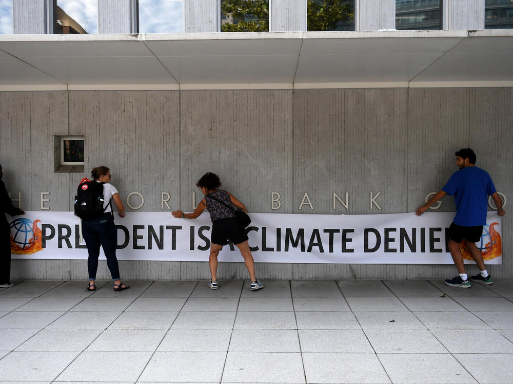 Activists unfurled a banner calling David Malpass a climate denier on the World Bank headquarters after he refused to say if he believed man-made emissions contributed to global warming.