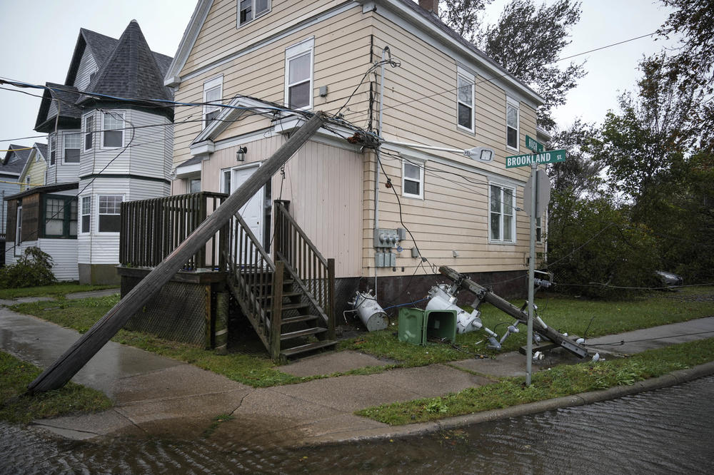 Downed power lines from winds from Post-Tropical Storm Fiona rest against a home in Sydney, Nova Scotia on Cape Breton Island in Canada.