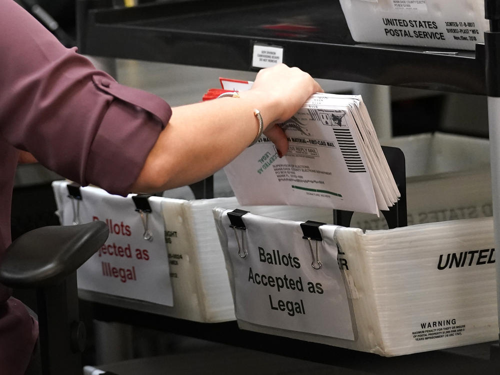 In this 2020 file photo, an election worker sorts vote-by-mail ballots at the Miami-Dade County Board of Elections in Doral, Fla. Florida is one of about half of U.S. states that have ballot curing provisions.
