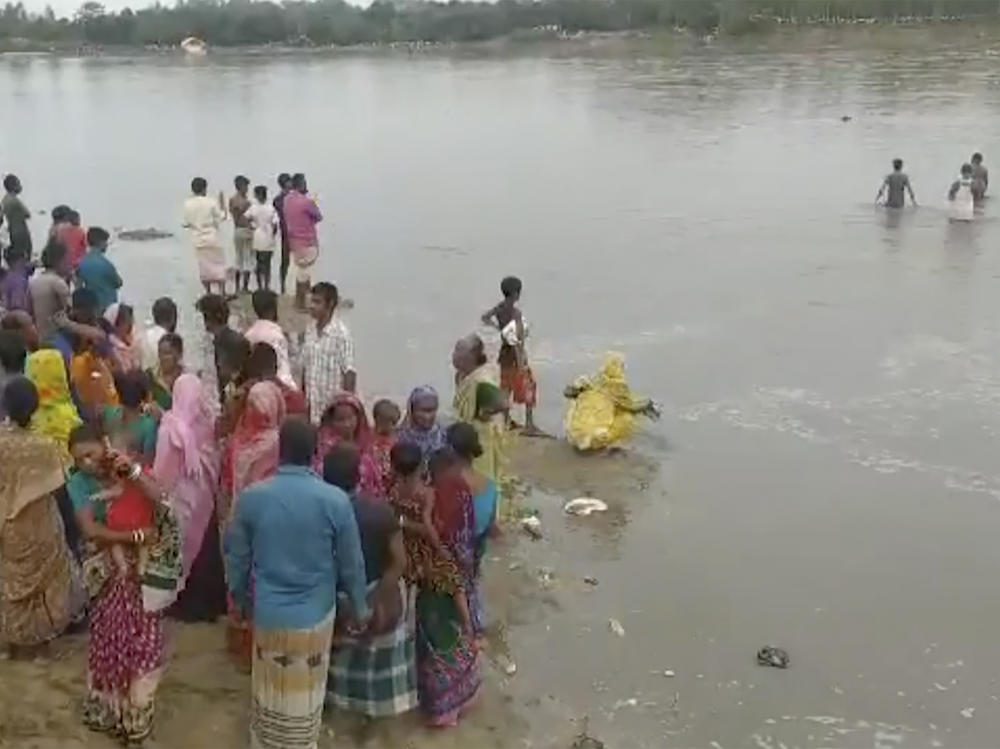 In this image made from a video, people conduct search operation in the River Karatoa, where an overcrowded boat overturned in Bangladesh on Sunday.