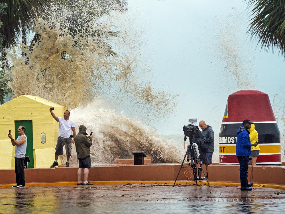 News crews, tourists and residents take images as high waves from Hurricane Ian crash into the seawall at the Southernmost Point buoy on  Tuesday in Key West, Fla.
