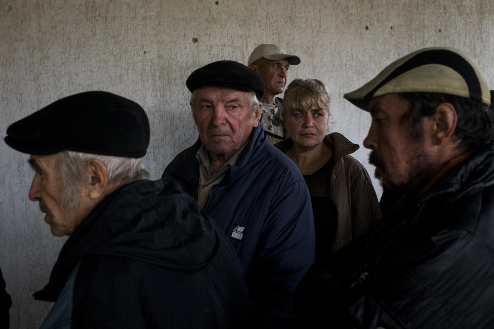 Civilians wait in line for humanitarian aid in Lyptsi, a village next to Borshchova, on Friday.