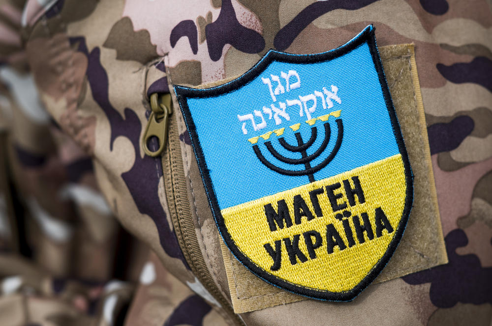 A soldier wears a patch featuring a menorah while standing guard in Uman on Monday. 