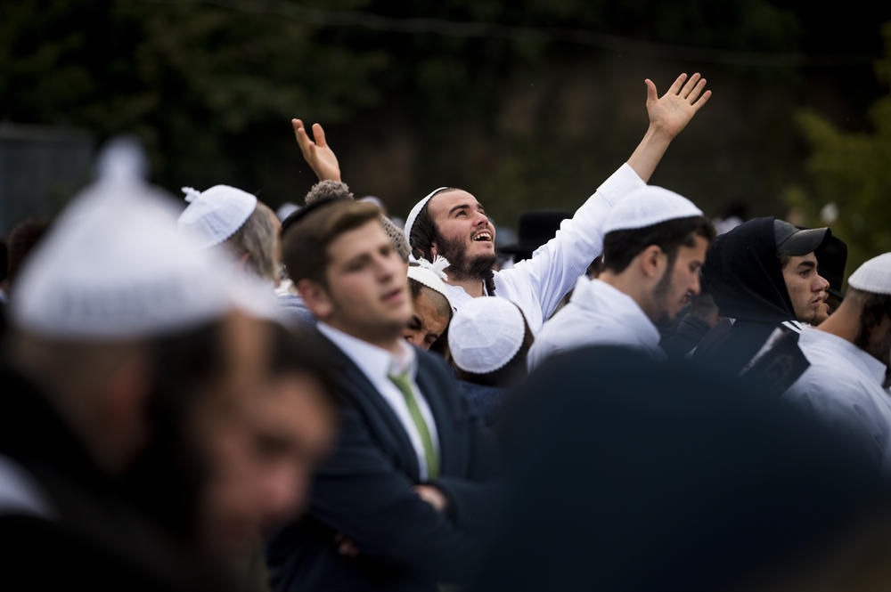 Hasidic pilgrims gather during Rosh Hashanah at a lake to perform Tashlikh, an atonement ritual that involves praying and symbolically casting one's sins into a body of water.