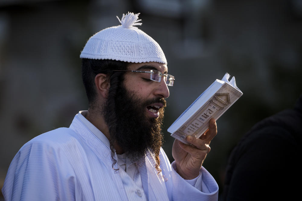 A Hasidic pilgrim performs Tashlikh near a lake in Uman.
