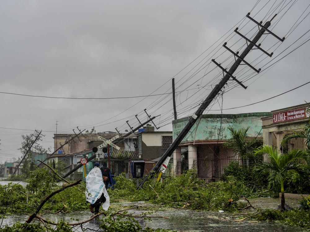 Fallen utility poles and branches line a street in Pinar del Rio, Cuba, on Tuesday after Hurricane Ian hit.