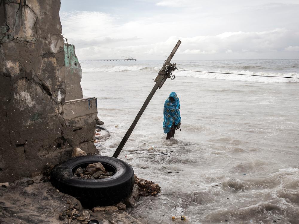 A woman looks at the damage outside her house, caused during a high tide period in Bargny, Senegal.