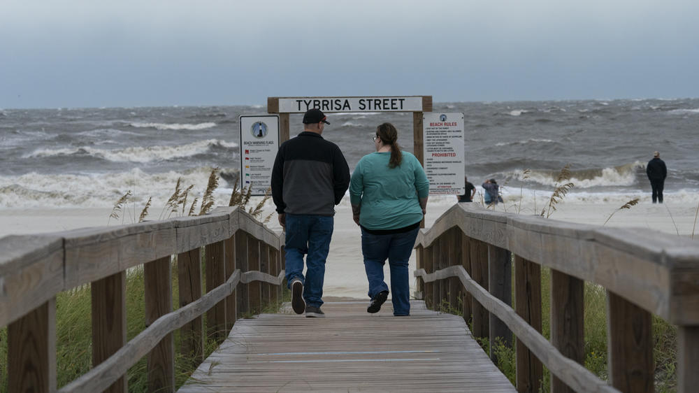 People walk to look at the ocean in Tybee Island, Ga., near Savannah, as the effects of Hurricane Ian reached the area early Thursday. The storm is expected to regain some strength over the Atlantic.