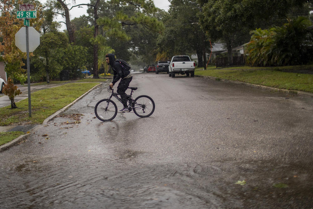 A person rides a bicycle in St. Petersburg, Fla., before Hurricane Ian hits the area on September 28, 2022.