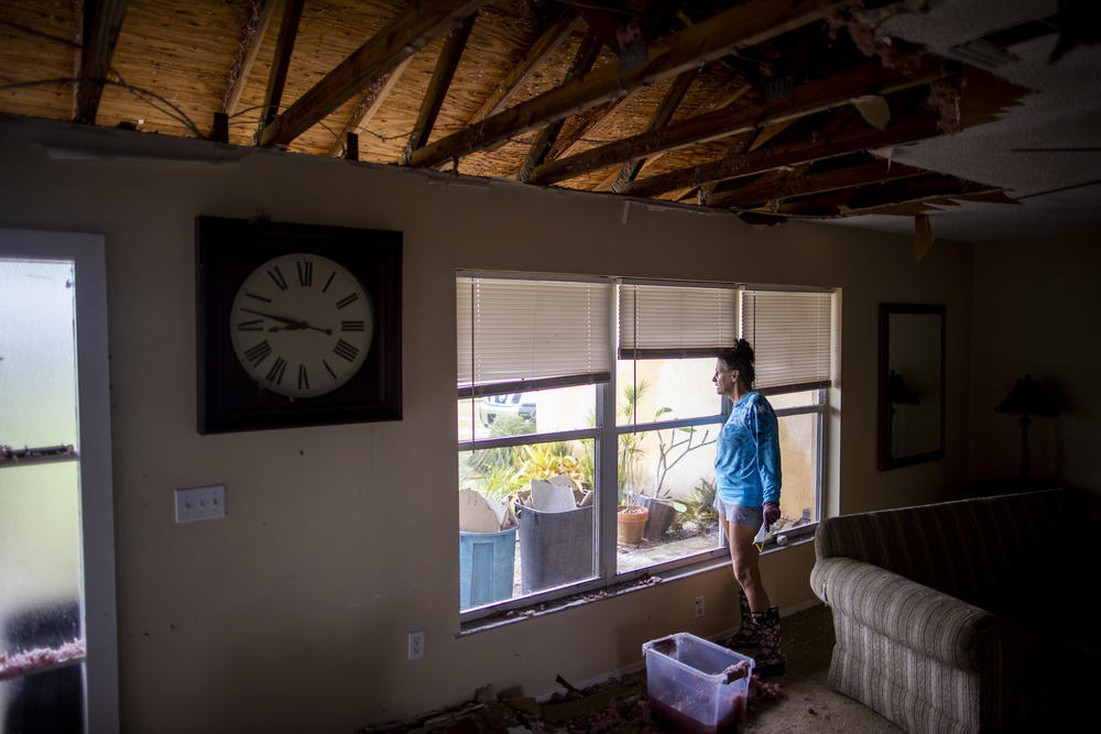 Charlene Goerlatz looks out the window of her home where the roof fell in after Hurricane Ian in Englewood Florida on September 29, 2022.