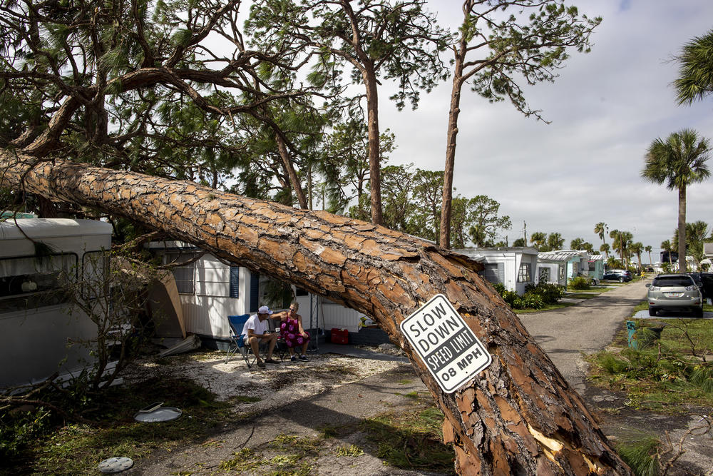 A couple sits in front of their home in Englewood Florida on September 29, 2022.
