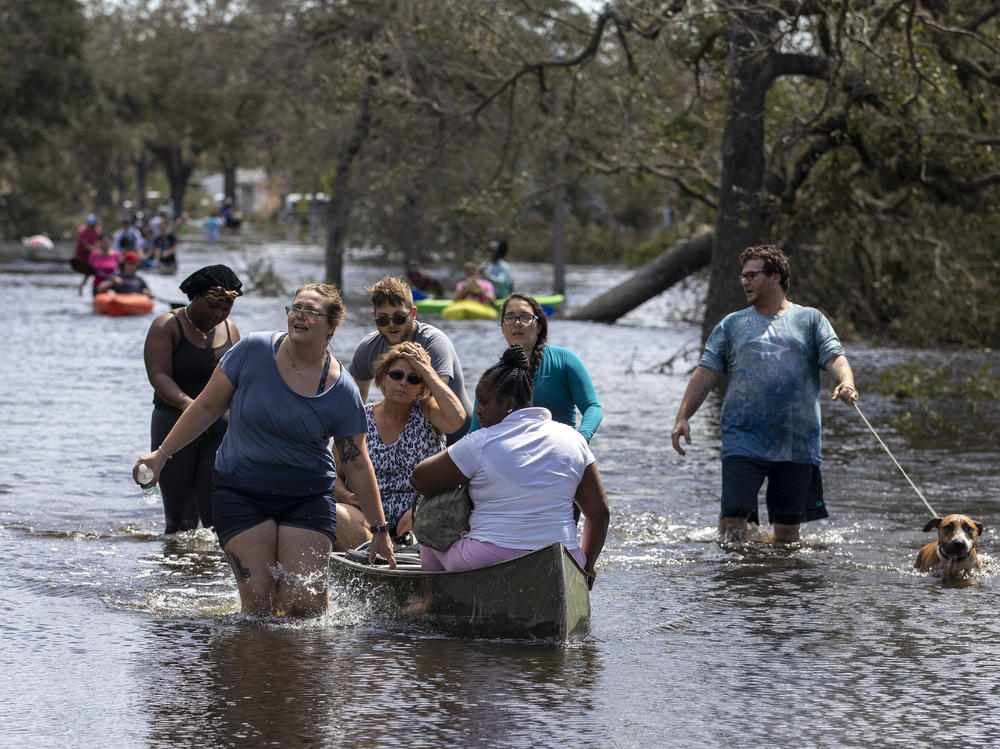 People leave the flooded community of Country Club Ridge in North Port Florida on September 29, 2022, after Hurricane Ian passed through the area a day earlier.