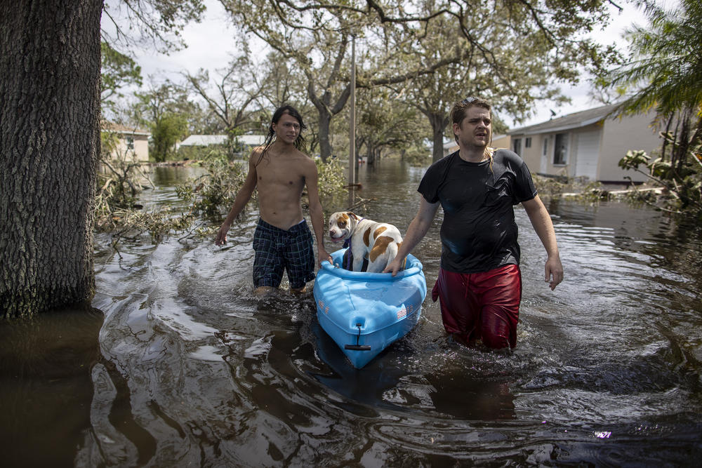 People leave the flooded community of Country Club Ridge in North Port Florida after hurricane Ian on September 29, 2022.