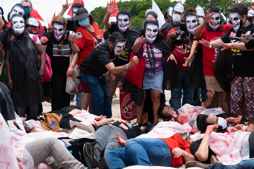 Protesters wearing masks depicting Bolsonaro perform during a protest against the government's COVID-19 response in Brasília on Oct. 20, 2021.