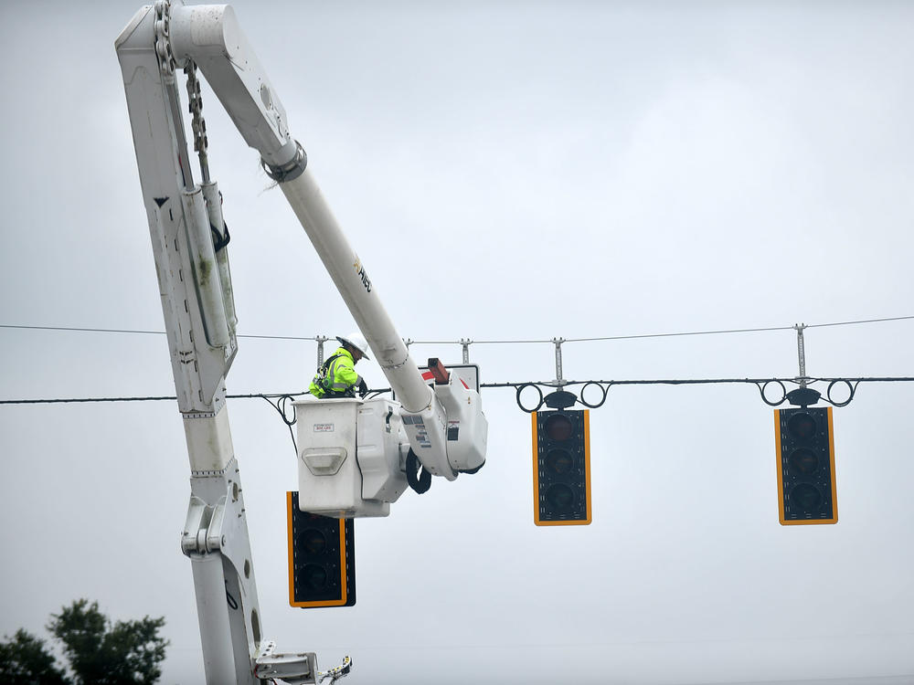 A worker repairs traffic lights during a power outage following Hurricane Ian on Thursday in Bartow, Fla.