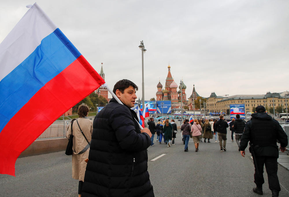 People approach screens located near the Kremlin and Red Square before the live broadcast of a ceremony to declare the annexation of the Russian-controlled territories of Ukraine's Donetsk, Luhansk, Kherson and Zaporizhzhia regions in Moscow on Friday. Russian authorities held referendums in the occupied areas of Ukraine that were condemned by Kyiv and governments worldwide.