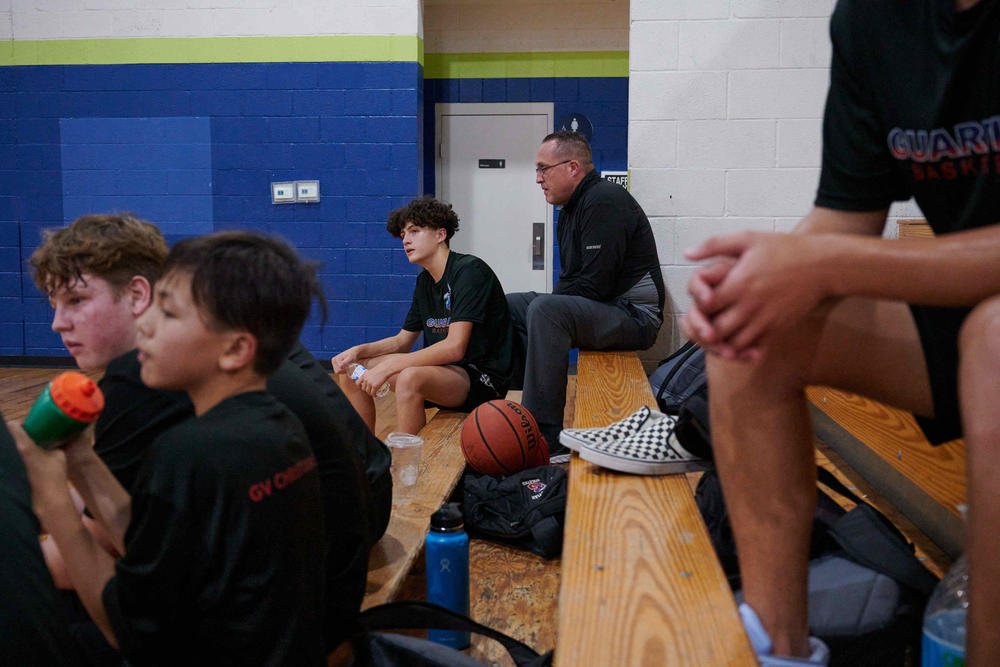 Survivor Chis Madsen, right, sits with his son Nick Madsen during a basketball practice in Las Vegas. 