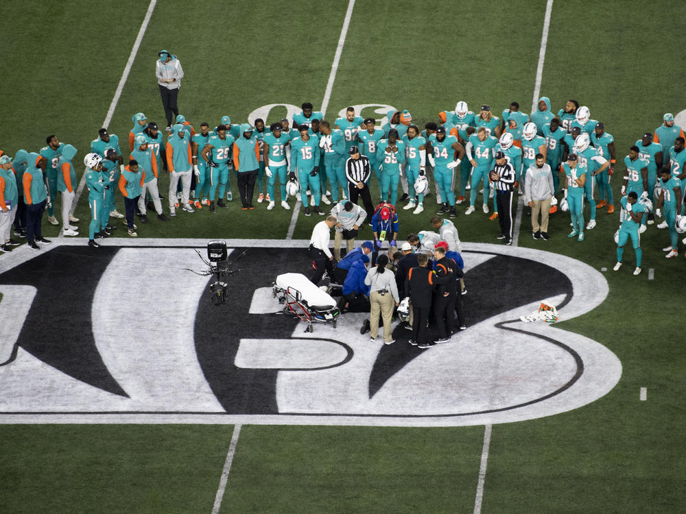 Teammates gather around Miami Dolphins quarterback Tua Tagovailoa (1) after an injury during the first half of an NFL football game against the Cincinnati Bengals, Thursday, Sept. 29, 2022, in Cincinnati.