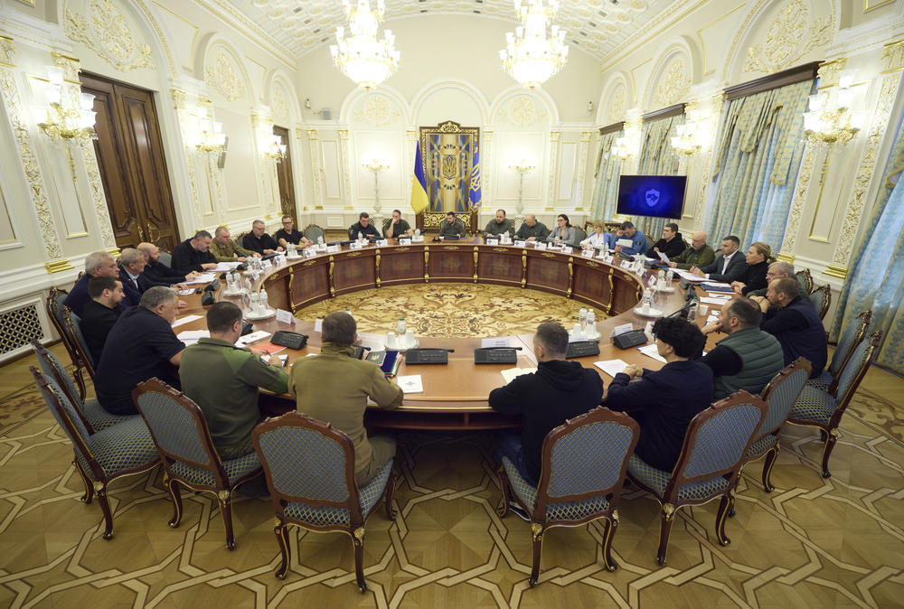 In this photo released by Ukrainian Presidential Press Office, Ukrainian President Volodymyr Zelenskyy, back center, leads a meeting of the National Security and Defense Council in Kyiv on Friday.