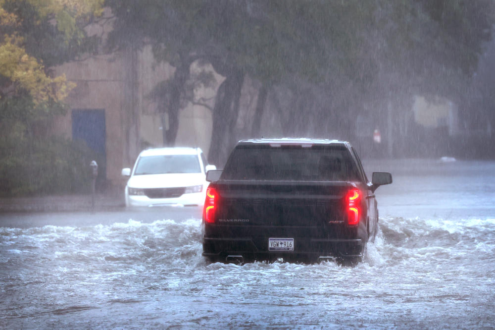 A vehicle drives down a flooded street as rain from Hurricane Ian drenches Charleston on Sept. 30.